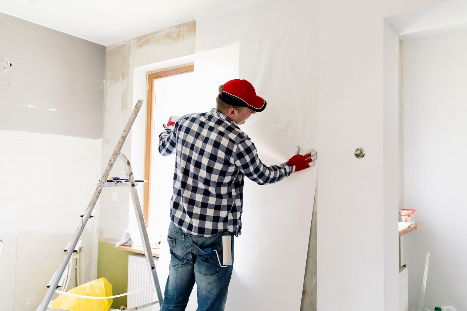 remodeling company man putting up drywall