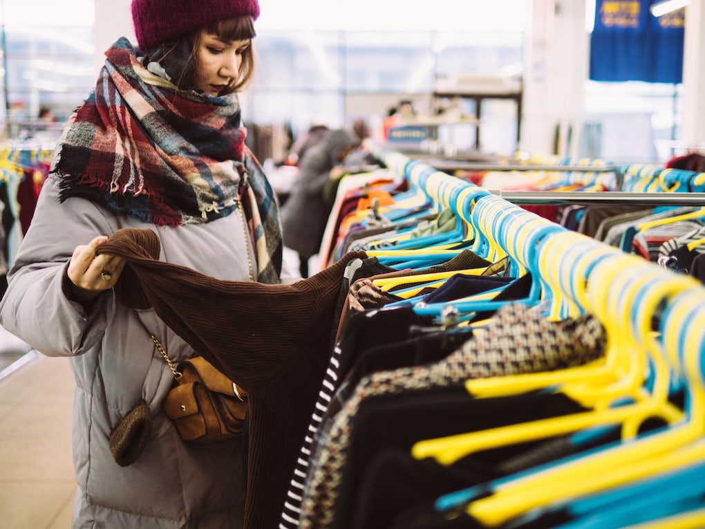 young woman browsing at a thrift shopping options in acton