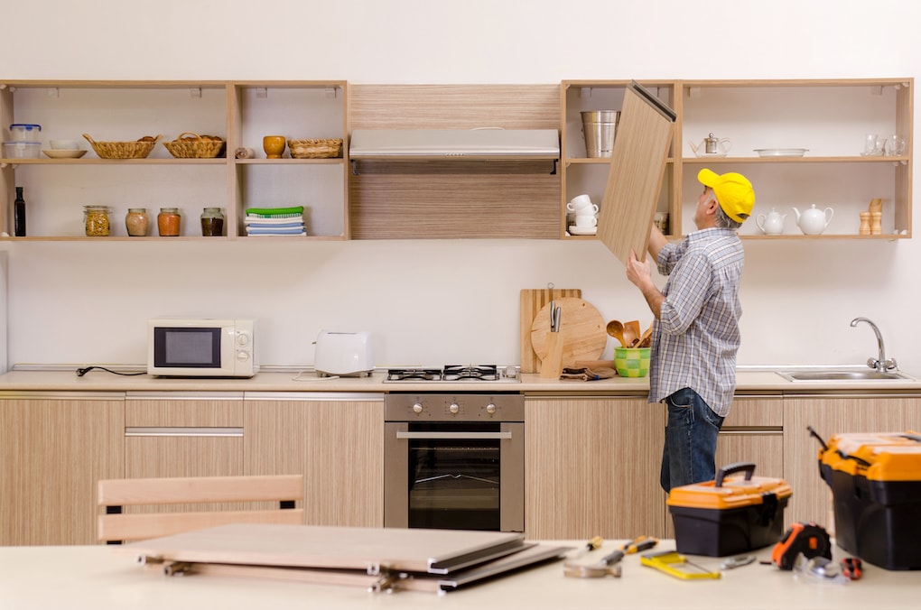 man replacing kitchen cabinets at home