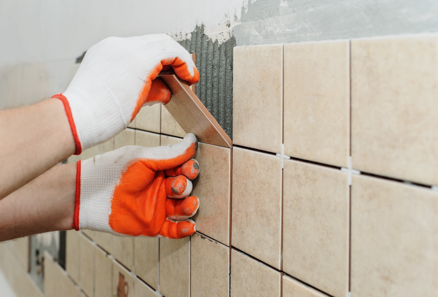 budget small bathroom remodel hands installing bathroom tile